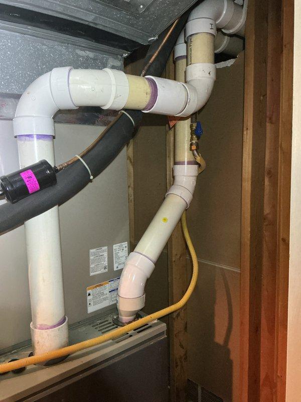 Completed comprehensive Gold AC inspection on 5-year-old residential air conditioning system with air handler located in basement. Verified system operational status and confirmed single-unit configuration. Performed thorough examination of HVAC components including evaporator coil, blower assembly, condensate drainage system, and electrical connections. Inspected integrated humidifier unit mounted to ductwork, verifying proper water supply lines and electrical connections. Evaluated PVC condensate drain piping configuration and checked for proper pitch and drainage flow. Assessed copper refrigerant lines for insulation integrity and signs of wear. Examined ductwork connections and sealed joints. Verified all safety controls, tested thermostat operation, and confirmed adequate airflow throughout system. Documented equipment condition with photographic records showing humidifier installation, mechanical room plumbing configuration, and associated utility connections. System found to be 