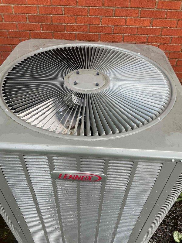 # Gold AC Inspection Completed

Performed comprehensive Gold-level preventive maintenance inspection on a one-year-old Lennox air conditioning condenser unit located in the backyard. Conducted thorough visual assessment of the exterior cabinet, confirming proper structural integrity with minimal weathering consistent with normal operation. Inspected the top-mounted fan assembly, including radial fan blades and central hub, verifying secure mounting and absence of physical damage or excessive wear.

Examined horizontal louvered ventilation panels on unit sides for unrestricted airflow and proper clearance from surrounding landscaping. Verified adequate clearance from brick wall and ground-level vegetation to maintain optimal air circulation around the condenser. Checked unit mounting stability on ground pad and confirmed level positioning.

Inspected electrical connections, refrigerant lines, and manufacturer labeling for proper documentation. Evaluated overall system condition, noting 