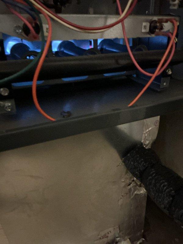 Responded to callback for furnace with no heat and error code in laundry room. Upon inspection, found natural gas furnace (Model XG40T06EC35U0, manufactured June 2014) still experiencing operational failure. Diagnosed system with blue flame present in combustion chamber, indicating ignition sequence initiating but heating cycle not completing. Verified refrigerant lines and service connections, documented equipment condition with illuminated evaporator coil visible through plenum access. Addressed recurring issue preventing heat production, cleared error code, and restored system to proper operation.