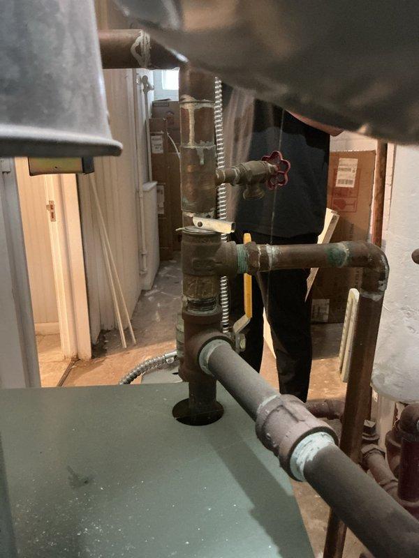 Responded to no heat call for one room in residence with 10+ year old steam boiler system located in basement. Performed diagnostic inspection of steam heating system and associated distribution piping. Examined boiler operation, steam supply lines, radiator connections, and air venting components serving affected zone. Inspected steam trap operation, checked for proper pitch on horizontal steam mains, and verified radiator valve functionality. Evaluated pressure controls, water level, and overall system operation. Identified issue preventing adequate steam delivery to single room radiator. Documented existing plumbing infrastructure including water heater installation, supply piping network with gate valves, and copper distribution lines showing normal aging patina. Explained findings to homeowner and provided recommendations for restoring proper heat distribution to affected area.