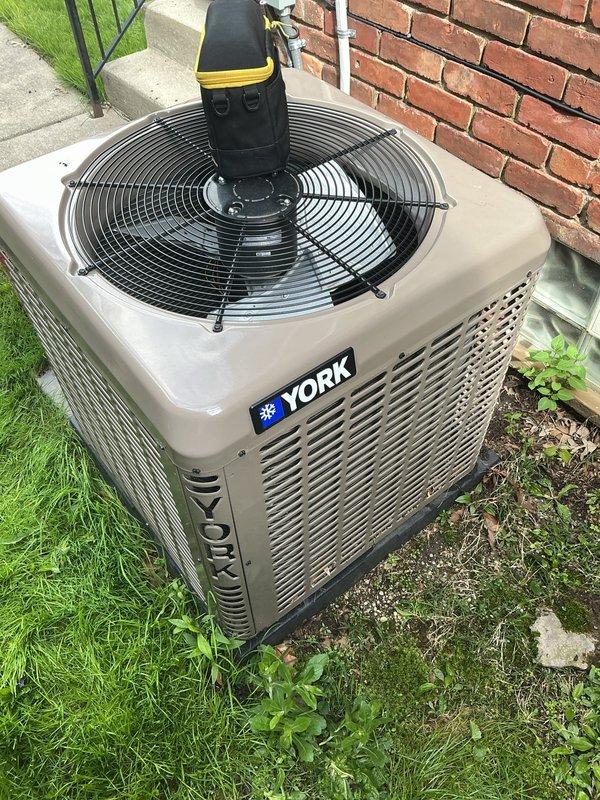 Completed comprehensive Gold AC inspection on 4-year-old York residential air conditioning system with outdoor condensing unit and basement air handler. Performed full system diagnostics and operational testing on properly functioning single-zone cooling system. Conducted thorough visual inspection of outdoor condenser unit positioned on concrete pad, verified proper installation clearances, checked refrigerant line insulation along exterior wall, and assessed overall equipment condition. All components operating within manufacturer specifications with no immediate service needs identified.