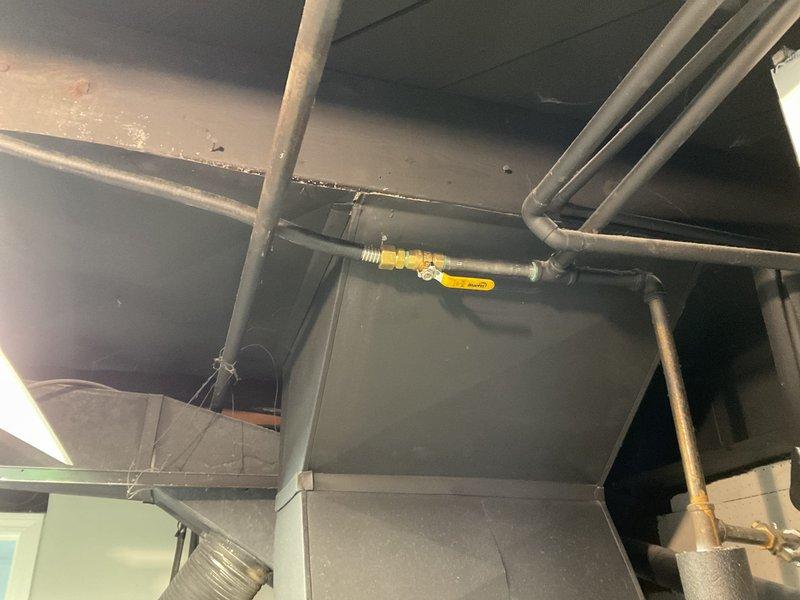 Completed commercial gas line installation in mechanical/utility space. Routed new gas piping through ceiling area, connecting to existing infrastructure with proper joints and fittings. Installed wall-mounted support bracket and secured gas line with appropriate mounting hardware per code requirements. All connections tested and tagged for identification. System ready for operation.