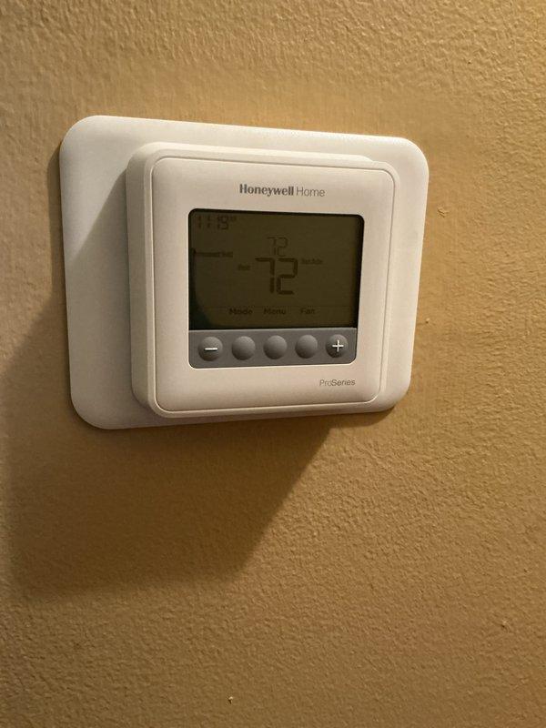 Completed comprehensive Gold AC inspection on a 1-year-old residential HVAC system with air handler located in basement. All equipment found in proper working condition. Inspected air handler unit, ductwork connections, condensate drain line with functioning valve, and Honeywell Home ProSeries thermostat set at 72 degrees. Verified system operation, checked all accessible components including metal supply and return ducts, flexible duct connections, and PVC drain piping. Unit operating within normal parameters with no deficiencies noted. Documented system condition with photographs for service records.