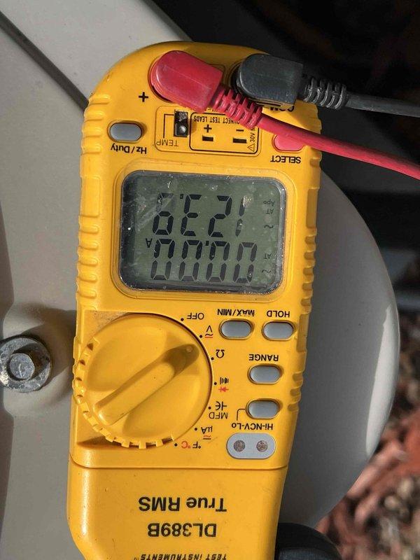 Completed comprehensive tune-up and performance evaluation on 10-year-old Bryant air conditioning system. Performed visual inspection of outdoor condenser unit, verified proper electrical readings using digital multimeter showing normal voltage levels, and confirmed system operational status. Documented equipment condition with photographic records for maintenance history.