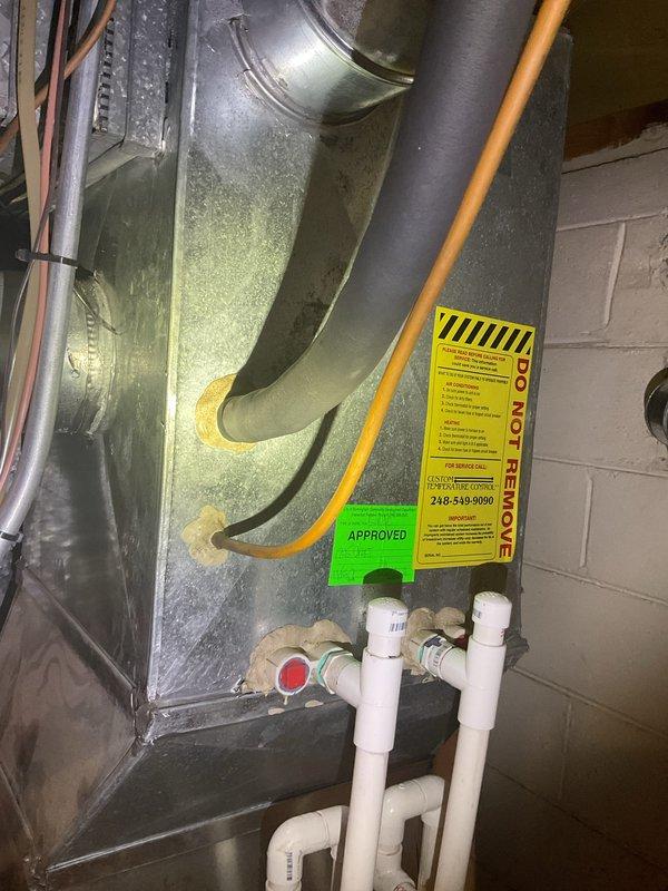 Completed comprehensive Gold AC inspection on 8-year-old York residential cooling system with air handler located in basement. Performed full system evaluation including indoor and outdoor unit assessment, verified operational status of all components, checked refrigerant lines and electrical connections, inspected condensate drainage system with white PVC piping, and examined ductwork connections. System found to be in proper working order with no immediate service requirements identified. Applied approved certification sticker to indoor unit upon completion of inspection protocol.