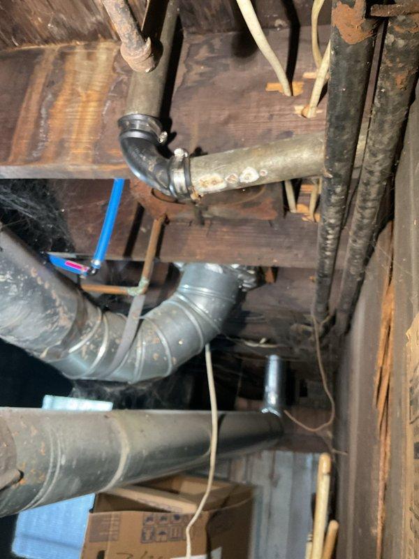 Responded to kitchen sink backup in 111-year-old home. Accessed plumbing system through crawlspace to inspect drainage configuration and P-trap assembly beneath sink. Cleared obstruction from drainage line, verified proper flow through PVC trap assembly and corrugated drain line connections. Tested system to ensure complete drainage restoration and confirmed all connections were secure with no leaks present.