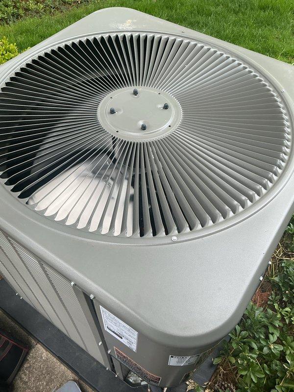 Completed comprehensive Gold AC Inspection on two residential air conditioning systems, both less than one year old and currently operational. Performed thorough visual examination of outdoor condenser units, verifying proper installation on concrete pads with adequate clearance and drainage. Inspected fan grilles, housing integrity, and external components for signs of damage, corrosion, or premature wear. Confirmed manufacturer labels and data plates are intact and legible. Evaluated ventilation louvers for unrestricted airflow and assessed overall unit condition. Air handler and coil system located in basement was included in multi-unit inspection protocol. All equipment found to be in good working order with no immediate service needs identified. Photographic documentation captured for maintenance records.