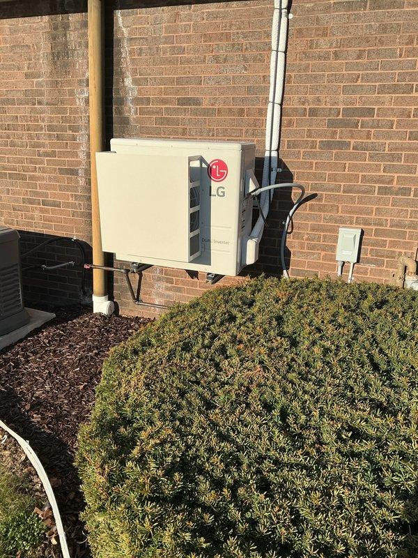 Responded to service call for commercial mini split system that would not power on despite battery replacement in remote. Upon arrival, inspected LG inverter outdoor unit mounted on exterior wall and indoor air handler installation. Diagnosed system issue and documented equipment condition with photos showing outdoor condensing unit and indoor component installation in crawl space area.