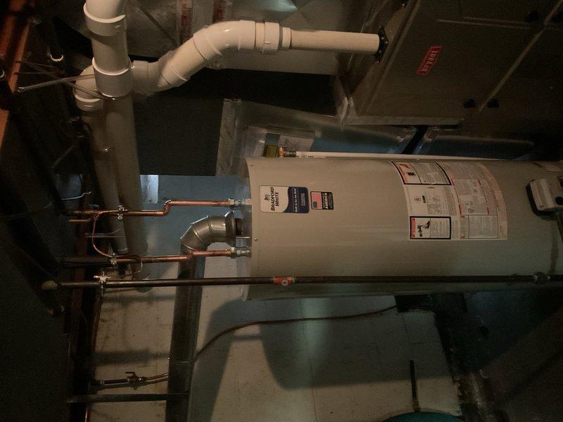 Completed installation of 50-gallon residential tank-style water heater in basement utility room. Established all necessary water supply connections using copper piping with brass fittings at the unit's inlet and outlet ports, installed pressure relief valve with proper discharge piping, and completed electrical reconnection to the control unit. Verified all plumbing connections for proper seal integrity, confirmed adequate clearances around the unit for service access and code compliance, and tested system operation to ensure proper heating function and thermostat response.