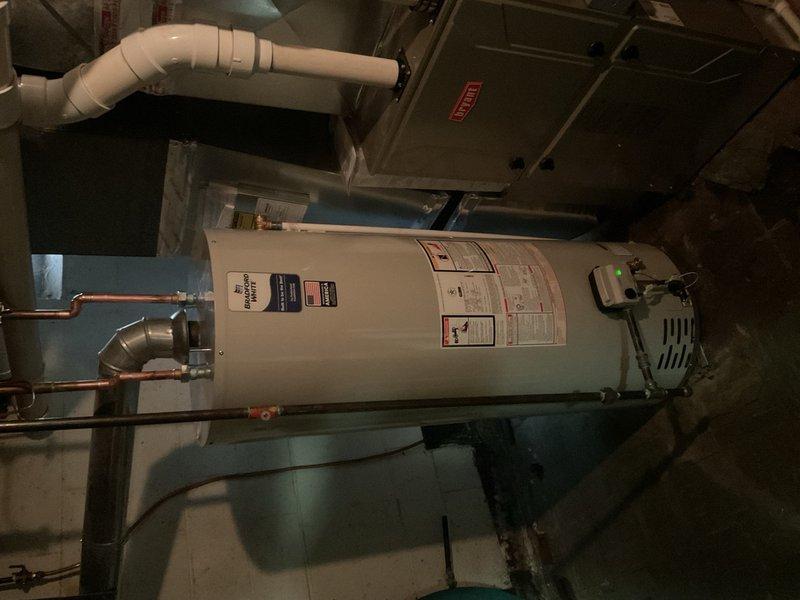 Completed installation of 50-gallon residential tank-style water heater in basement utility room. Established all necessary water supply connections using copper piping with brass fittings at the unit's inlet and outlet ports, installed pressure relief valve with proper discharge piping, and completed electrical reconnection to the control unit. Verified all plumbing connections for proper seal integrity, confirmed adequate clearances around the unit for service access and code compliance, and tested system operation to ensure proper heating function and thermostat response.