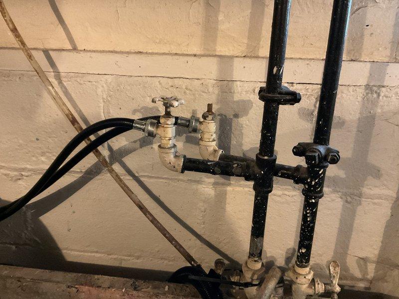 Conducted on-site assessment for water heater replacement, evaluating current 40-gallon tanked unit and determining appropriate capacity requirements for household demand. Inspected existing plumbing infrastructure including supply lines, shut-off valves, and venting system in basement utility area. Examined aging laundry sink valve assembly with corroded brass fixtures and deteriorating shut-off controls serving washing machine supply lines. Provided professional recommendations for upgrading to appropriately-sized tanked water heater unit and replacing worn laundry room plumbing valves to ensure reliable water supply and prevent potential leaks.