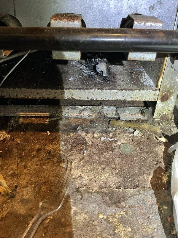 Performed comprehensive tune-up and safety inspection on residential boiler system located in basement. Verified all operational controls, pressure gauge readings, and safety valves including pressure relief valve functionality. Inspected combustion chamber, heat exchanger surfaces, and venting system for proper operation and signs of deterioration. Checked all piping connections, brass fittings, and isolation valves for leaks or corrosion. Examined electrical components and junction box connections for secure mounting and proper wiring. Noted significant rust and corrosion present on secondary piping in crawlspace area beneath unit, with evidence of moisture exposure and deteriorated conditions in surrounding utility space. Documented concrete block foundation showing water staining and aging, with exposed soil floor area containing debris accumulation. System currently operational with all primary safety controls functioning within normal parameters, though crawlspace conditions indi