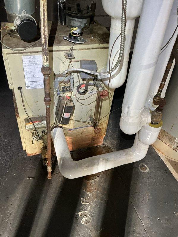 Completed routine tune-up and safety inspection on 10+ year old boiler system located in basement. Performed visual inspection of boiler unit, associated piping, ductwork, and mechanical components. Noted age-related wear including rust and corrosion on metal pipes and fittings, with newer PVC components in satisfactory condition. Verified proper operation of heating system, checked electrical connections and wiring, and confirmed drain pan placement for leak protection. All safety checks passed and unit operating within normal parameters at time of service.
