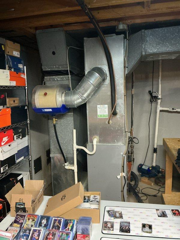 Performed diagnostic evaluation on 10-year-old residential R410A air conditioning system experiencing low refrigerant levels. Upon inspection, determined that system would require significant refrigerant recharge and potential leak repair. Provided comprehensive replacement estimate as alternative to repair given age and condition of existing equipment. Documented current HVAC installation including furnace, evaporator coil housing, and ductwork configuration in basement mechanical room for replacement planning purposes.