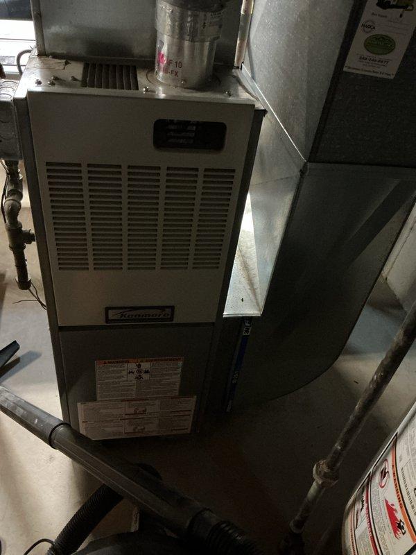 Performed diagnostic evaluation on 10-year-old residential R410A air conditioning system experiencing low refrigerant levels. Upon inspection, determined that system would require significant refrigerant recharge and potential leak repair. Provided comprehensive replacement estimate as alternative to repair given age and condition of existing equipment. Documented current HVAC installation including furnace, evaporator coil housing, and ductwork configuration in basement mechanical room for replacement planning purposes.