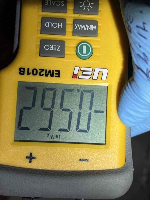Completed comprehensive Gold Plan AC inspection on 5-year-old residential cooling system with air handler located in basement. Unit found operating properly with condenser positioned on exterior pad against brick wall. Performed standard diagnostic measurements including voltage readings of 295V at disconnect, inspected condenser coil condition, verified fan operation, and checked refrigerant levels. Advised customer to maintain clear area around outdoor unit by removing debris, wood chips, and any animal waste to ensure proper airflow and system efficiency.