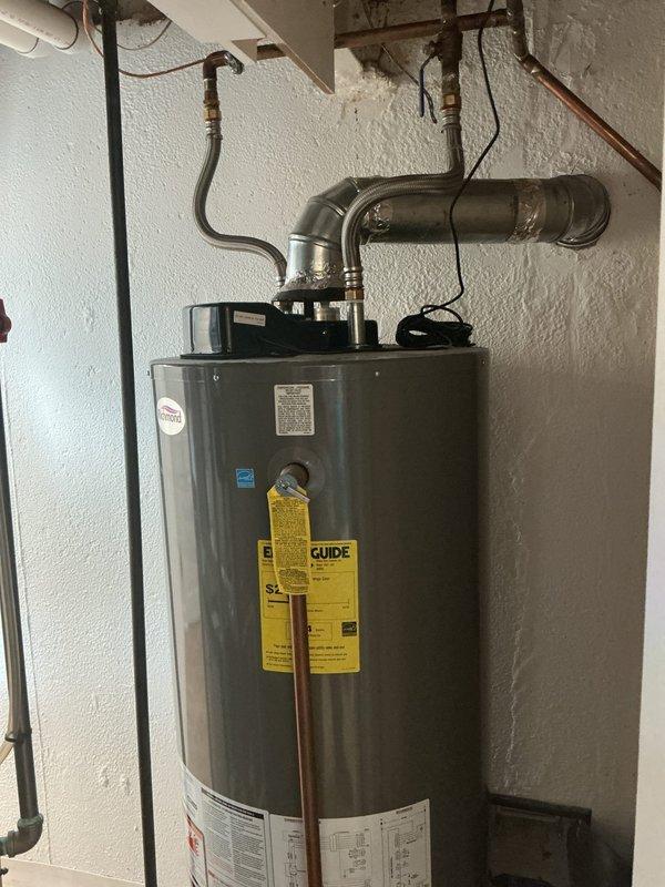 Responded to no hot water complaint at 54-year-old residence with 9-year-old water heater in basement. Upon arrival, confirmed water heater was cool to the touch and not producing hot water since previous evening. Performed diagnostic inspection of unit, including examination of gas supply line, pilot light assembly, thermocouple, gas control valve, and venting system. Verified proper gas flow to unit and checked all safety mechanisms and electrical connections. Inspected flue pipe and draft hood for proper ventilation and clearances. Documented current condition of water heater installation with photos showing unit positioning, piping connections, Energy Star rated tank, and overhead gas line configuration with brass fittings. Assessed overall system integrity including copper supply lines, shut-off valves, and temperature-pressure relief valve operation.