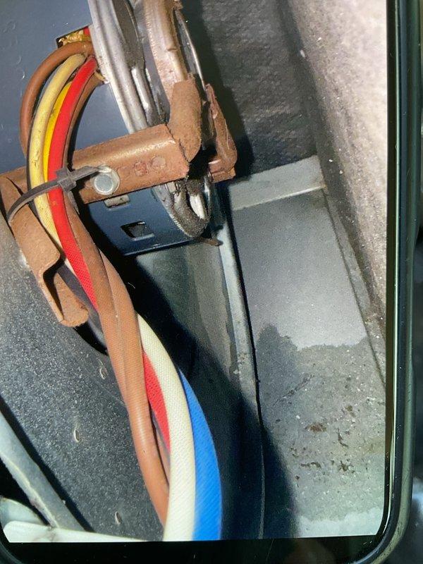 # HVAC Gold AC Inspection Completed

Performed comprehensive Gold-level air conditioning inspection on a single 10+ year old residential system with air handler located in basement. System was operational at time of service. 

Conducted thorough examination of refrigerant lines and electrical connections at indoor unit, noting foam insulation on copper refrigerant piping with age-appropriate wear. Verified proper routing of control wiring including multi-conductor thermostat and power supply connections through equipment cabinet.

Inspected outdoor condensing unit and discovered severe deterioration of electrical components. Found extensively corroded capacitor housing with heavy rust buildup on internal metal components and mounting hardware. Noted significant debris accumulation including cobwebs throughout electrical compartment indicating prolonged lack of maintenance. Documented corroded conduit connections and weathered wiring at outdoor unit base. Equipment shows advanced signs 