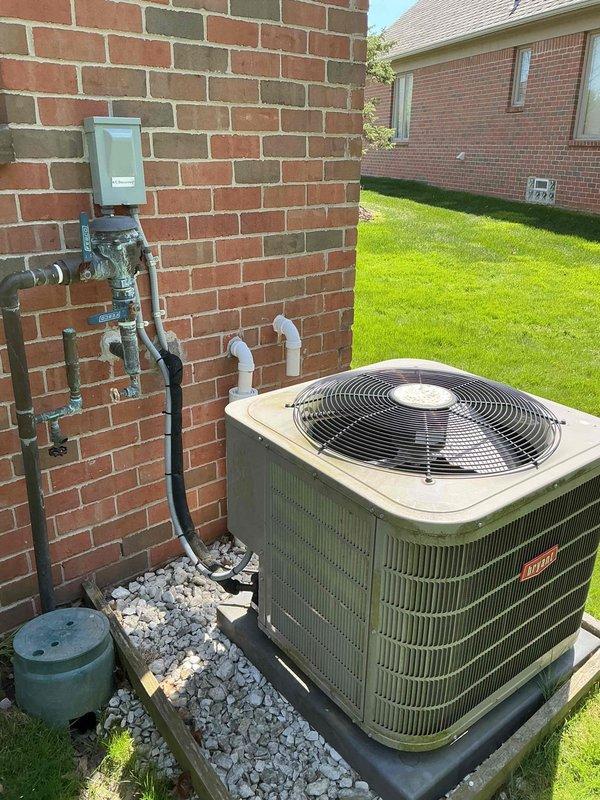 Completed comprehensive Gold AC inspection on 9-year-old Bryant air conditioning system with air handler located in basement. Performed full system evaluation including visual inspection of outdoor condenser unit, verified proper placement on pad with adequate clearance, inspected electrical disconnect and gas line connections mounted on exterior wall, and assessed refrigerant line routing. Checked condenser coil condition, fan operation, and overall unit integrity. Verified system operating under favorable weather conditions with ambient temperature above 65 degrees as required for accurate performance testing. Removed and disposed of filter packaging per protocol. Advised homeowner to maintain clear area around condenser unit, keeping it free from debris and animal waste to ensure optimal airflow and system efficiency. All system components found to be functioning properly with no immediate service needs identified. Unit exterior and surrounding installation area appear well-maintain