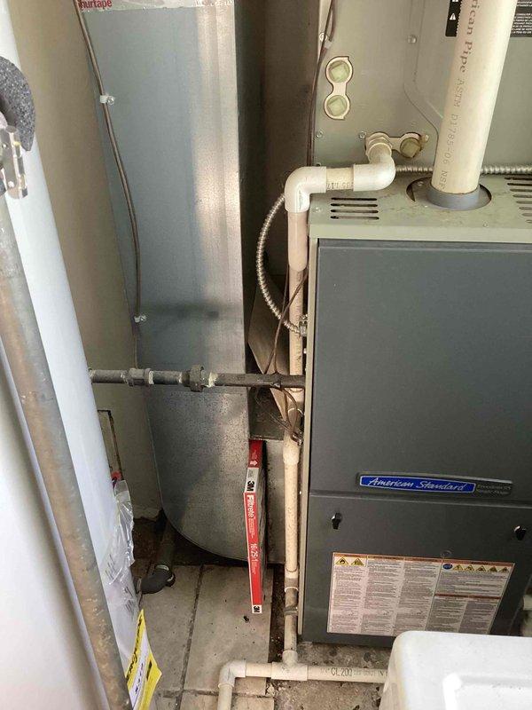 Performed comprehensive estimate inspection on 10+ year old HVAC system following identification of cracked heat exchanger in American Standard furnace unit located in basement mechanical room. Evaluated existing R410A air conditioning system and assessed feasibility of complete system replacement including furnace and AC unit. Documented current equipment configuration, ductwork connections, venting setup with white PVC exhaust/intake pipes, and overall system condition to provide homeowner with replacement options for full HVAC system upgrade.