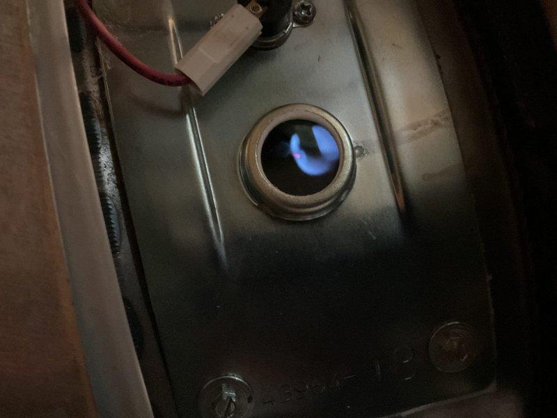 Responded to no hot water complaint in 85-year-old residential property. Upon inspection of basement water heater, diagnosed failed gas control valve preventing proper heating operation. Replaced defective gas control valve with new Honeywell WV88410A1057 24V actuator assembly. Verified proper gas combustion through observation port, confirmed blue flame pattern indicating correct air-fuel mixture. Tested hot water delivery throughout home, restored full functionality to tanked water heater system.