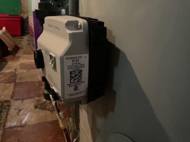 Responded to no hot water complaint in 85-year-old residential property. Upon inspection of basement water heater, diagnosed failed gas control valve preventing proper heating operation. Replaced defective gas control valve with new Honeywell WV88410A1057 24V actuator assembly. Verified proper gas combustion through observation port, confirmed blue flame pattern indicating correct air-fuel mixture. Tested hot water delivery throughout home, restored full functionality to tanked water heater system.