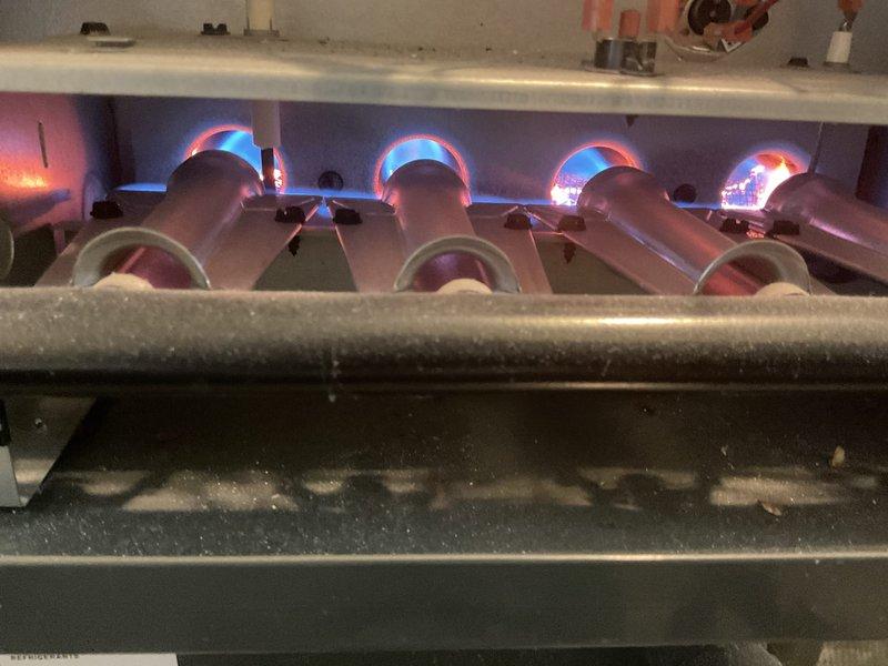 Completed comprehensive tune-up on 6-year-old gas furnace located in kitchen. Inspected burner assembly and confirmed proper ignition with clean blue flames and normal orange tipping on all four burners. Examined air filter which showed moderate dust accumulation and discoloration; noted filter condition for replacement consideration. Verified equipment operational status with all components functioning within normal parameters.