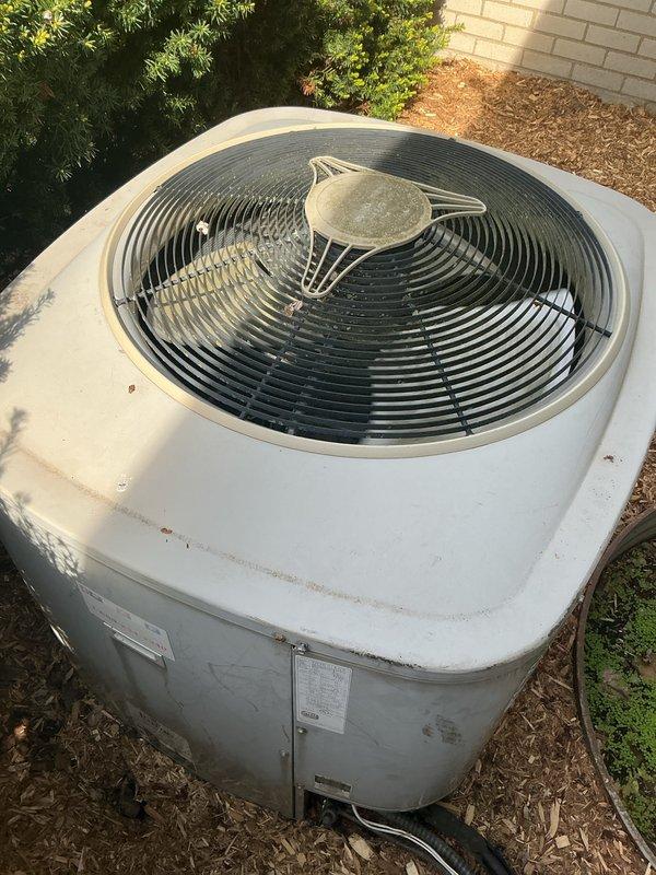 Completed comprehensive Gold AC inspection on operational system with air handler located in basement. Verified proper operation of under-10-year-old equipment and documented outdoor condenser unit condition with cylindrical white housing positioned on ground pad with mulch base. Advised customer to maintain clear area around condenser unit, removing any debris and animal waste to ensure optimal airflow and system performance.
