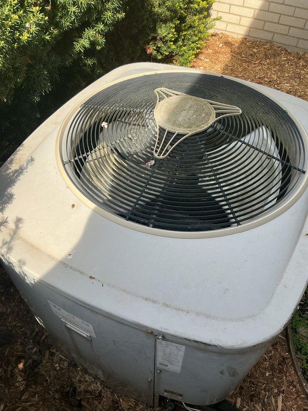 Completed comprehensive Gold AC inspection on operational system with air handler located in basement. Verified proper operation of under-10-year-old equipment and documented outdoor condenser unit condition with cylindrical white housing positioned on ground pad with mulch base. Advised customer to maintain clear area around condenser unit, removing any debris and animal waste to ensure optimal airflow and system performance.