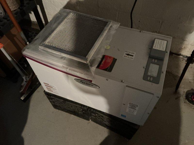 Responded to service call for AprilAire Model E100 whole-home dehumidifier displaying E4 error code and failing to maintain operation after startup. Inspected unit in basement, documented equipment condition and manufacturer specifications. Low temperature sensor/frost sensor identified as required component for repair, with part to be supplied under existing purchase order for future installation.