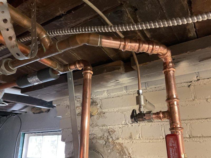 Completed installation of a 50-gallon standard tanked water heater in basement utility area. Installed new copper supply lines with proper compression fittings and valves, including boiler drain connections for future maintenance access. Performed miscellaneous plumbing repairs including securing exposed piping to ceiling joists with appropriate mounting brackets and straps. All connections were properly soldered and tested for leaks. System was commissioned and verified operational upon completion.