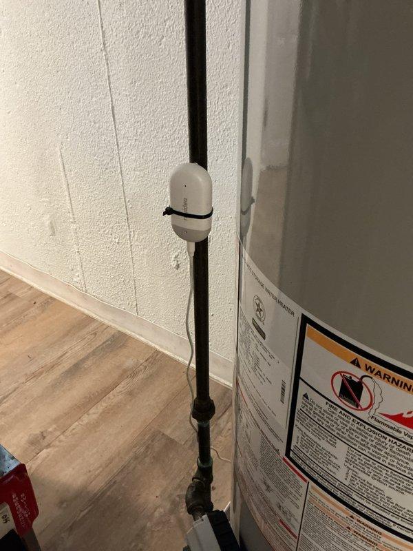 Completed installation of residential tanked water heater in utility room. Connected copper supply lines with brass fittings to unit, installed exhaust venting system with proper pitch and termination, and verified all connections for code compliance. Mounted temperature and pressure relief valve, installed drain pan safety sensor with monitoring device secured to discharge pipe, and set temperature controls to manufacturer specifications. All plumbing connections pressure tested and system commissioned successfully with hot water delivery confirmed throughout residence.