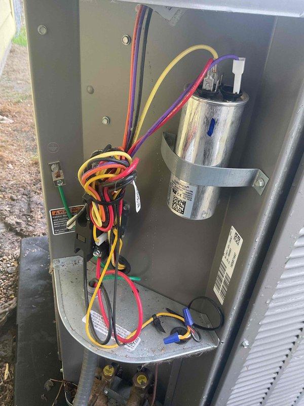 Completed comprehensive Gold AC inspection on residential HVAC system less than one year old with air handler located in utility room. Installed four new air filters, inspected electrical components including capacitor and wiring connections which were found to be in good working order, and documented outdoor condenser unit showing significant dirt accumulation and discoloration on coil fins requiring future cleaning attention. All system components tested and operational at time of inspection.