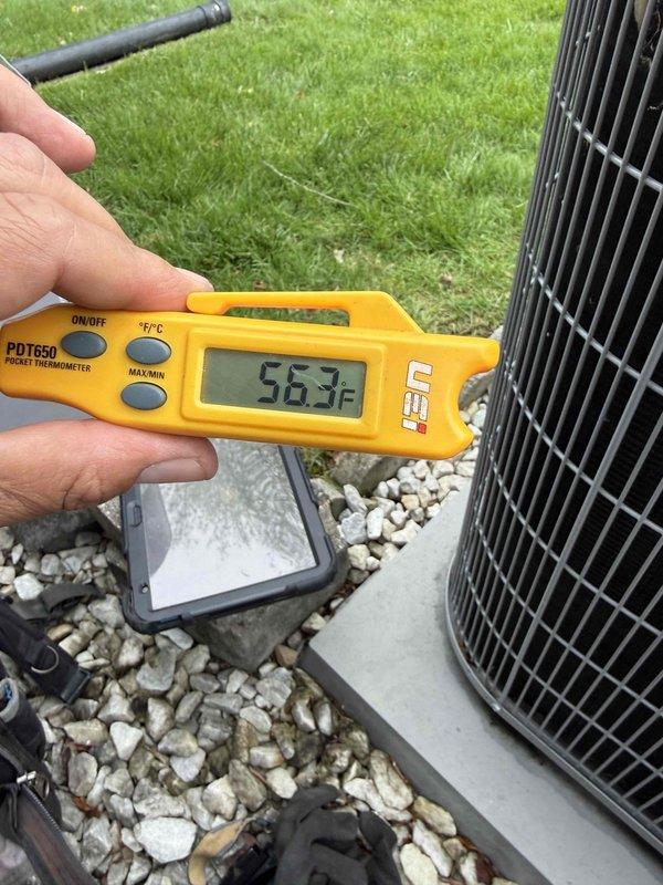 Completed comprehensive Gold AC inspection on 10-year-old residential cooling system with air handler located in basement. Performed standard diagnostic testing and visual examination of outdoor condenser unit and associated components. Documented ambient temperature reading of 56.3°F at time of inspection. Observed condenser unit positioned on concrete pad with decorative stone surround; noted presence of garden ornament on top of unit and advised customer that area surrounding condenser should be kept clear of debris and any animal waste to ensure proper airflow and system efficiency. Verified electrical disconnect box installation and refrigerant line routing. System operational at time of inspection with all components functioning within normal parameters.