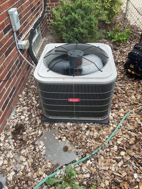 Completed comprehensive Gold AC Inspection on Bryant outdoor condensing unit with air handler located in basement. Performed full system evaluation including visual inspection of condenser coil fins, fan assembly operation, electrical connections at disconnect box, and refrigerant line condition. Unit found properly positioned on concrete pad with adequate clearance, though surrounding area showed seasonal debris accumulation. Documented equipment condition with photographs showing exterior cabinet integrity and internal component access points. System operational at time of inspection with no immediate service needs identified.