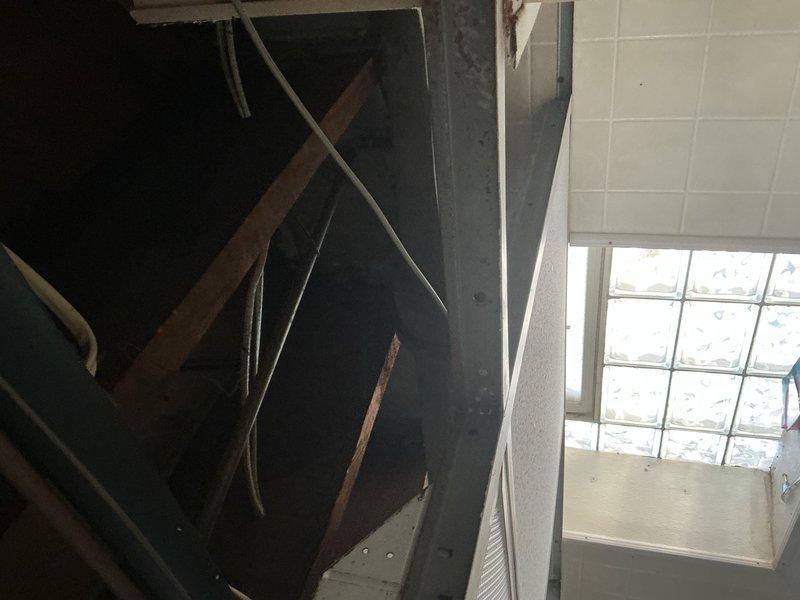 Responded to emergency call for burst pipes in basement caused by freezing conditions. Upon arrival, conducted thorough inspection of affected area and documented damage to plumbing infrastructure. Multiple frozen pipes had ruptured, resulting in water damage to basement ceiling and surrounding structural components. Photographed exposed ceiling cavity showing damaged pipe sections, wooden support beams, and affected building materials. Documented water intrusion points and extent of damage to acoustic ceiling tiles and adjacent wall surfaces. Assessed basement utility area where burst pipes were located, noting water damage patterns on concrete walls and floors. Provided comprehensive visual documentation of all damaged components for insurance claim purposes, including detailed photographs of compromised plumbing system and resulting structural impact.