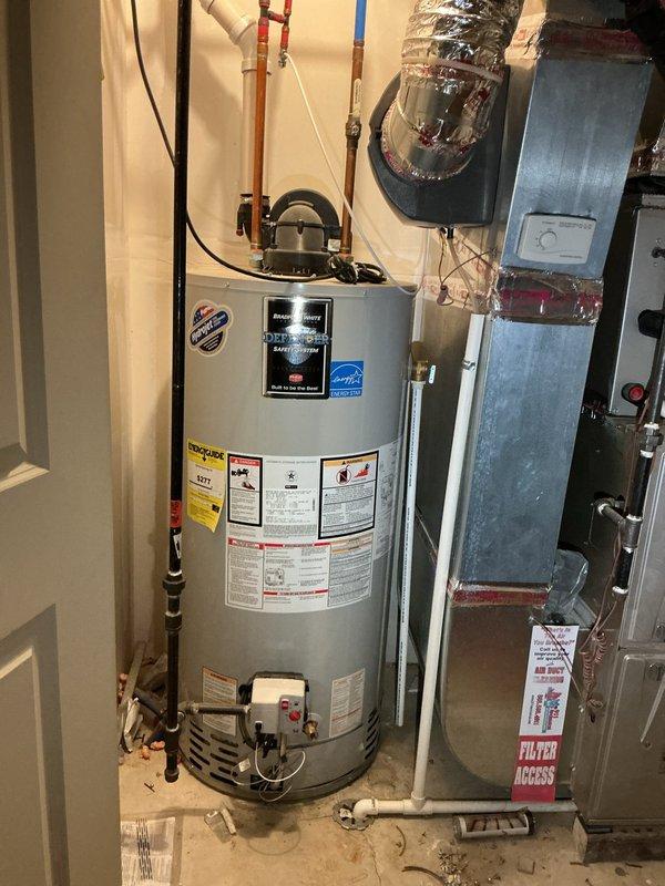 Responded to no hot water complaint at four-year-old residence with tanked water heater located on fourth floor utility room. Upon arrival at scheduled morning appointment, inspected 40-50 gallon gas-fired residential water heater with visible Energy Star rating and standard safety equipment including temperature/pressure relief valve. Diagnosed pilot light failure as cause of complete loss of hot water throughout home. Relit pilot assembly, verified proper flame characteristics, and tested burner ignition sequence. Confirmed unit returned to normal operation with adequate hot water production and proper exhaust venting through exterior wall termination. Verified all safety controls functioning correctly before clearing service call.