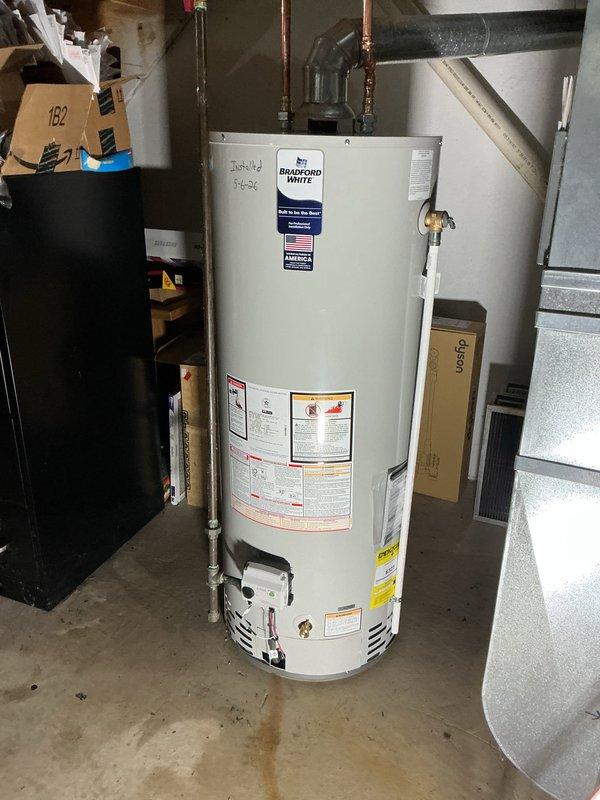 Completed installation of a 50-gallon Bradford White tanked water heater in basement utility area. Configured copper supply piping with brass shut-off valves, installed expansion tank, and connected flexible gas line to unit. All plumbing connections were properly secured and tested to ensure system functionality and code compliance.