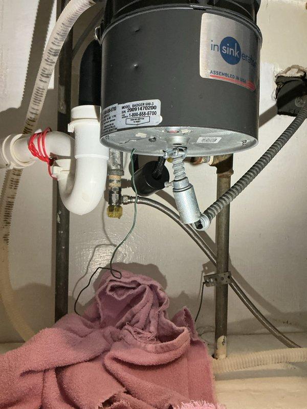 Replaced existing valve under kitchen sink to accommodate new dishwasher installation. Verified proper connections to InSinkErator garbage disposal unit, confirmed all PVC drain lines and P-trap assembly were secure, and tested water supply lines for leaks. Installation now ready for dishwasher hookup.