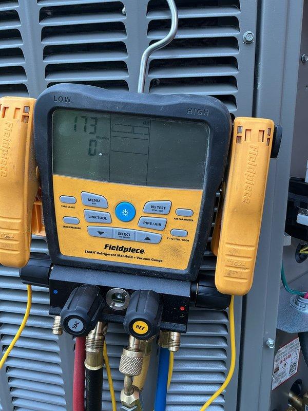 Completed installation of 2-ton air conditioning unit with evaporator coil at rear location. Installed new air handler with integrated coil, connected refrigerant lines, installed condensate drainage system using PVC piping, and performed electrical reconnection. System was evacuated, charged with refrigerant to manufacturer specifications, and tested using digital manifold gauges to verify proper pressures and operation.
