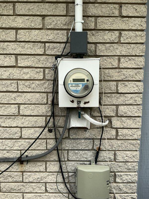 Performed comprehensive electrical assessment for electric vehicle charging station installation feasibility, evaluated existing electrical panel condition and capacity, and conducted whole home electrical system inspection. Documented current meter configuration, exterior service entrance components, and interior panel with existing circuit breaker arrangement to determine necessary upgrades for EV charger integration. Provided detailed analysis and recommendations for main electrical panel replacement to support increased load requirements.