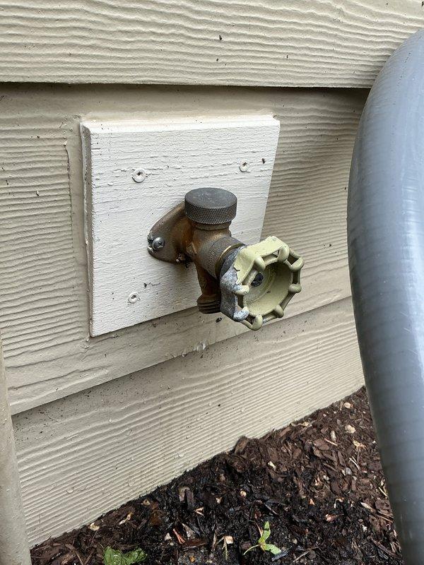 Responded to service call for leaking outdoor water spigot at rear of property. Upon inspection, identified deteriorated hose bib with compromised valve seat and worn packing causing active water seepage at connection point. Shut off water supply at interior shutoff valve located beneath adjacent fixture. Removed existing weathered brass hose bib from exterior wall penetration, inspected copper supply line for corrosion or damage, and confirmed integrity of pipe threading. Installed new frost-proof hose bib with anti-siphon vacuum breaker, applied appropriate thread sealant to ensure watertight connection, and secured mounting flange to siding. Restored water supply, tested valve operation through multiple open/close cycles, and verified complete elimination of leak at spout and wall connection. Confirmed proper drainage and functionality before completion.