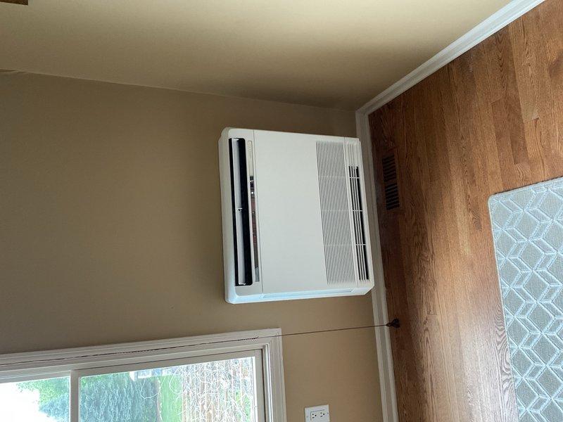 Completed full mini split system installation in residential bedroom, including wall-mounted indoor air handler unit positioned high on interior wall above window for optimal air distribution. Coordinated with licensed electrician for new dedicated circuit installation and subpanel work to support system electrical requirements. Installed outdoor condensing unit, ran refrigerant line set and condensate drain through wall penetration, pressure tested system, evacuated lines, charged with refrigerant per manufacturer specifications, and verified proper operation of all heating and cooling functions.