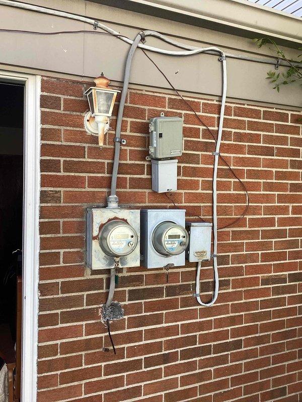 Conducted site assessment for replacement estimate of 1.5-ton York Expedition air conditioning unit at residential property. Documented existing exterior electrical service configuration including dual meter setup, disconnect switch, and conduit routing on brick exterior wall. Inspected interior mechanical room containing current HVAC air handler, ductwork system, and associated utility equipment to determine compatibility requirements and installation parameters for proposed replacement unit.