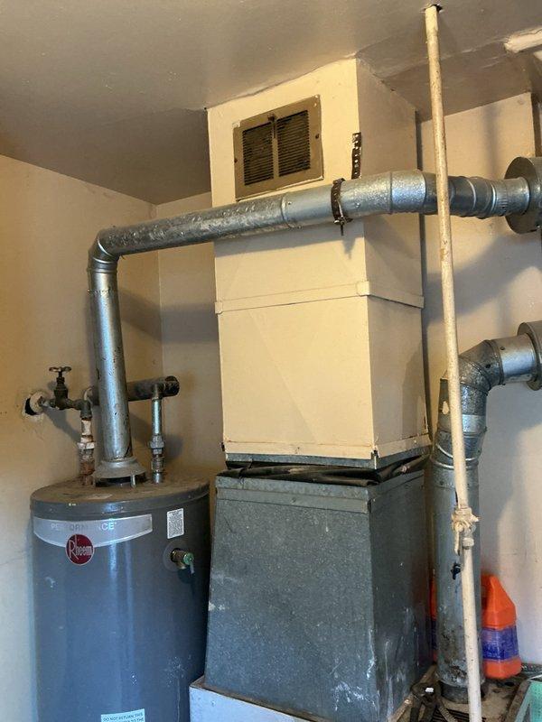 Responded to water leak complaint in utility room. Upon inspection, identified leaking pipes connected to Rheem water heater. Assessed plumbing connections, valves, and supply lines for source of leak. Documented equipment condition and leak location through photo documentation of water heater, surrounding piping infrastructure, and HVAC system in mechanical space. Provided customer with findings and recommended repair options to resolve active leak condition.