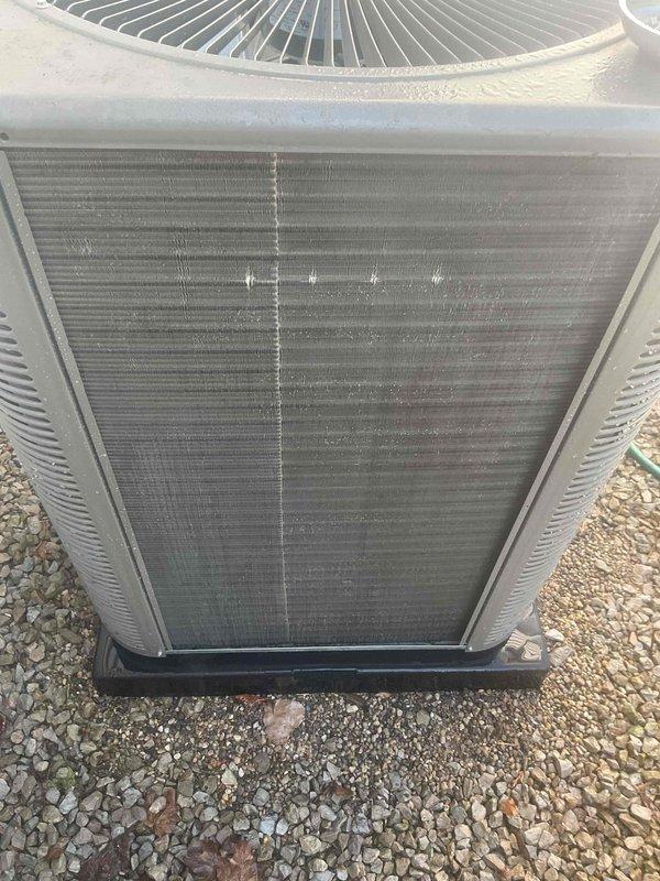 Completed comprehensive Gold AC inspection on 2-year-old Lennox system with air handler located in laundry room. Inspected outdoor condenser unit, noting dirt and debris accumulation on coil fins requiring attention, verified system operational status, and documented equipment condition through photographic records. Unit confirmed functioning properly with homeowner present, condenser positioned on proper pad with adequate clearance from structure.