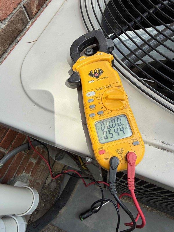 Completed comprehensive Gold AC inspection on multi-unit residential HVAC system with 10-year-old equipment, including two outdoor condenser units and basement-located air handler. Performed electrical diagnostics using clamp meter to verify proper amperage draw and voltage readings on both condensers, inspected condenser coils through protective grilles, evaluated unit housings for wear and weathering, and confirmed both systems operational. All equipment functioning within normal parameters at time of inspection.