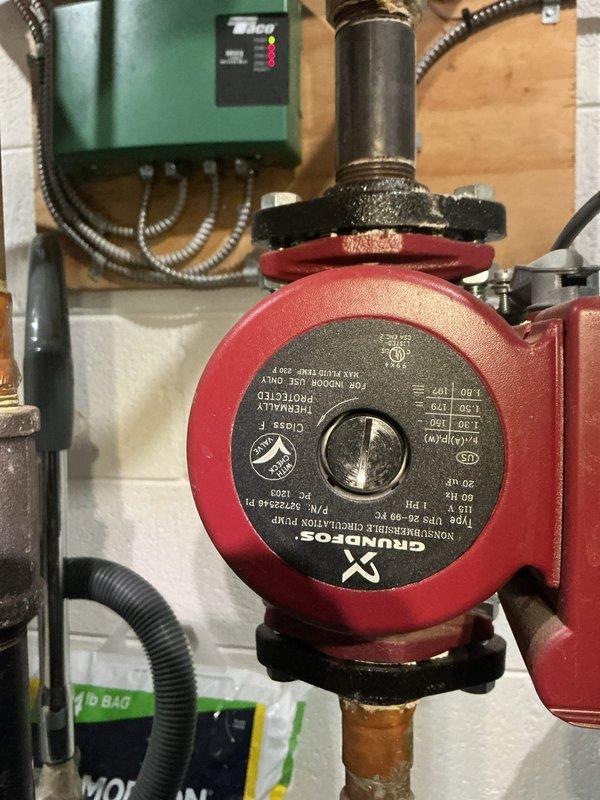 Responded to service call for boiler system displaying blockage error and not operating properly. Upon arrival, performed diagnostic inspection of 10+ year old boiler system located in basement. Examined Grundfos circulation pump and associated control components, noting operational status of Taco zone control panel with multiple indicator lights. Inspected copper piping connections and Legend valve assembly, observing turquoise-green corrosion and mineral deposits on brass valve body indicating copper oxidation. Assessed system for potential blockages in circulation system and verified proper pump operation. Documented equipment condition through photographs showing circulation pump, control panel status, and valve assembly with visible corrosion buildup. Diagnostic evaluation completed to determine cause of blockage error and system malfunction.