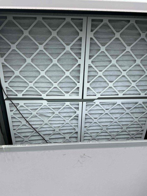 Performed scheduled maintenance on four rooftop HVAC units at commercial facility. Accessed units via extension ladder to complete inspection and service procedures. Inspected and documented condition of air filtration system, noting filters showed moderate dust accumulation with visible discoloration on pleated media. All four filters in 2x2 configuration were evaluated for airflow restriction and operational efficiency.