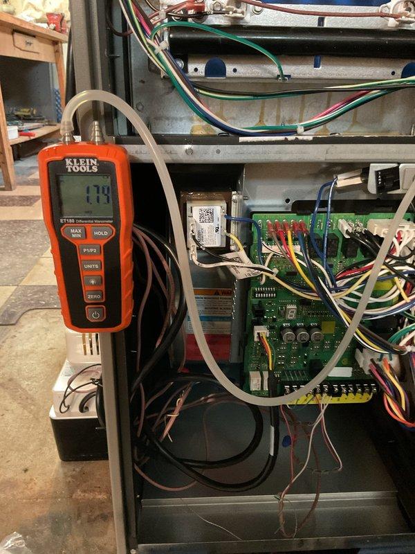 Completed AC system startup and commissioning for basement installation. Performed comprehensive diagnostics using digital manometer to verify static pressure readings at 2.13 inches w.c., confirming proper airflow and duct system performance. Verified electrical system operation with multimeter reading 248 volts, checked all control board functions including LED indicators, and confirmed proper wiring connections throughout the unit. All components operating within manufacturer specifications.